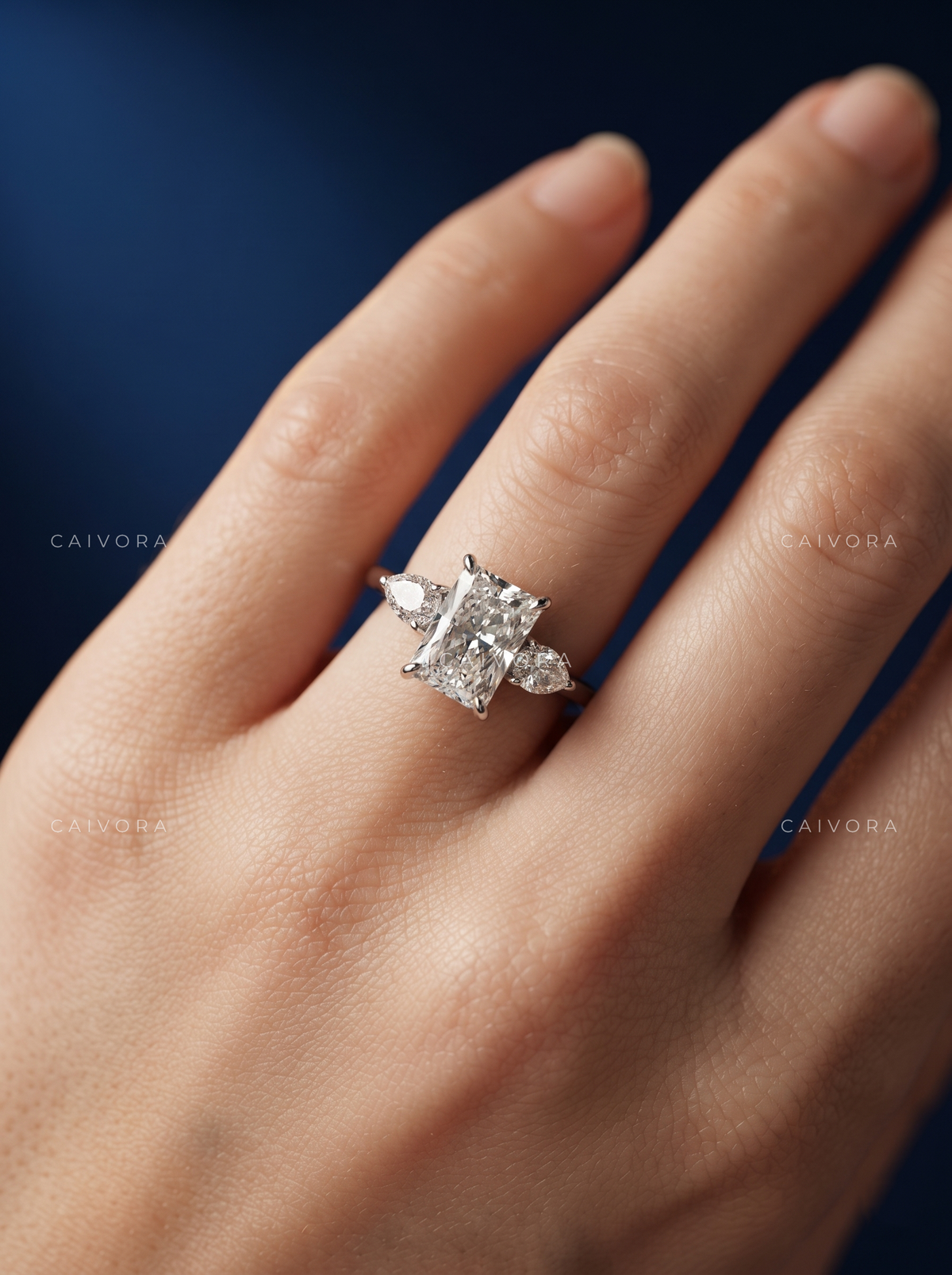 Refined Three Stone Setting Framed by a Radiant Cut Center Diamond