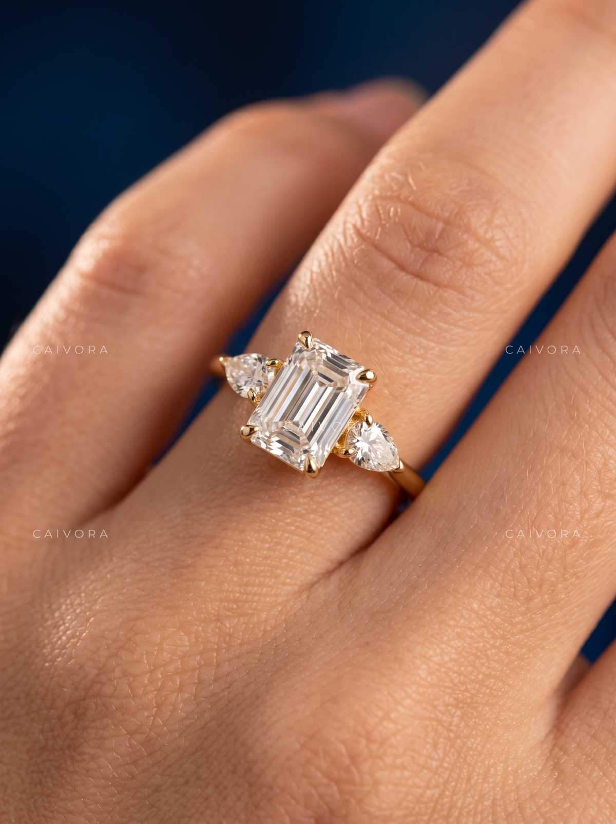 Modern Three Stone Engagement Ring Showcasing an Emerald Cut Center Diamond