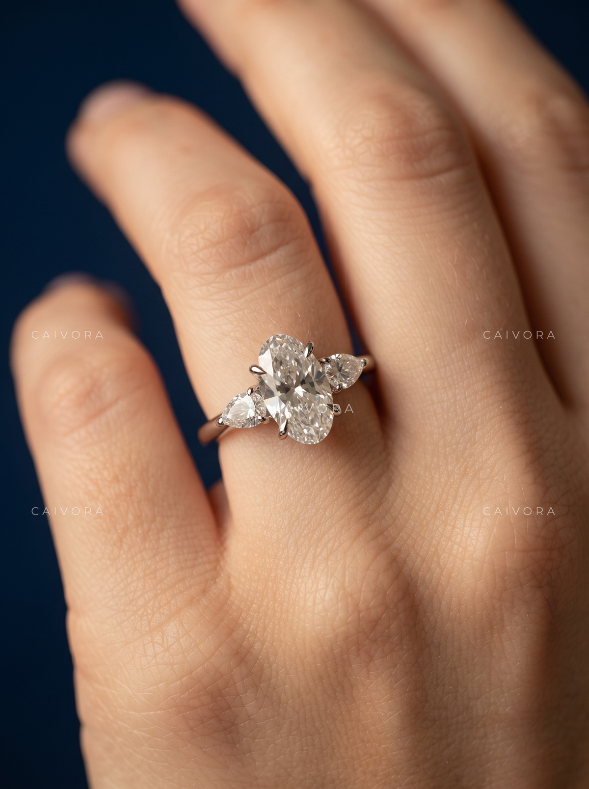 Graceful Three Stone Silhouette with an Moval Cut Center