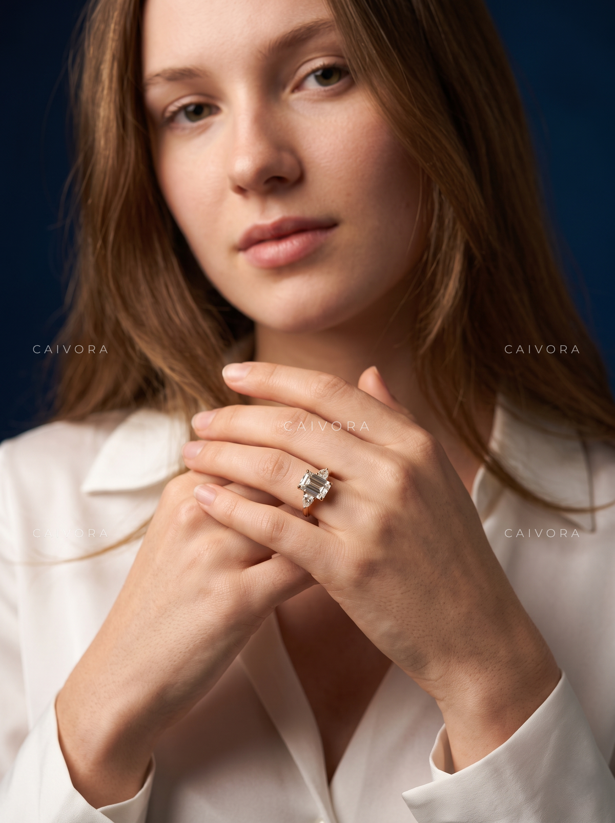 Modern Three Stone Engagement Ring Showcasing an Emerald Cut Center Diamond