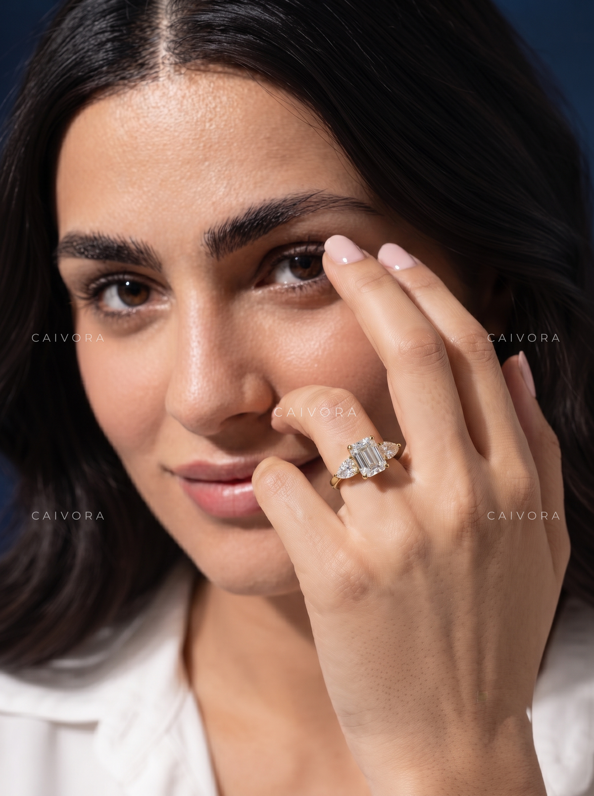 Modern Three Stone Engagement Ring Showcasing an Emerald Cut Center Diamond